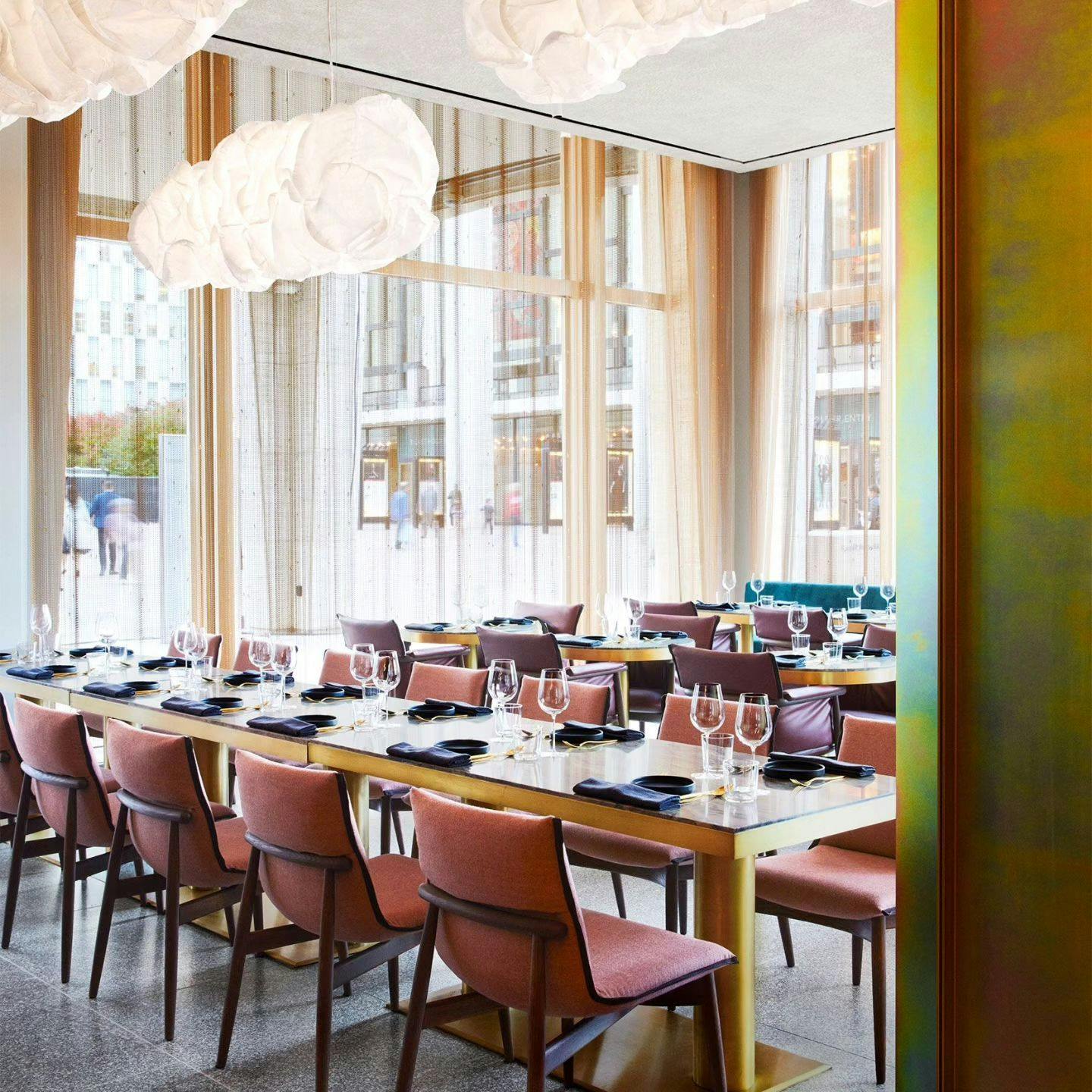 An elegant, modern restaurant interior bathed in natural light, featuring chic furniture and pristine table settings, inviting a sophisticated dining experience offered through Booked in New York.