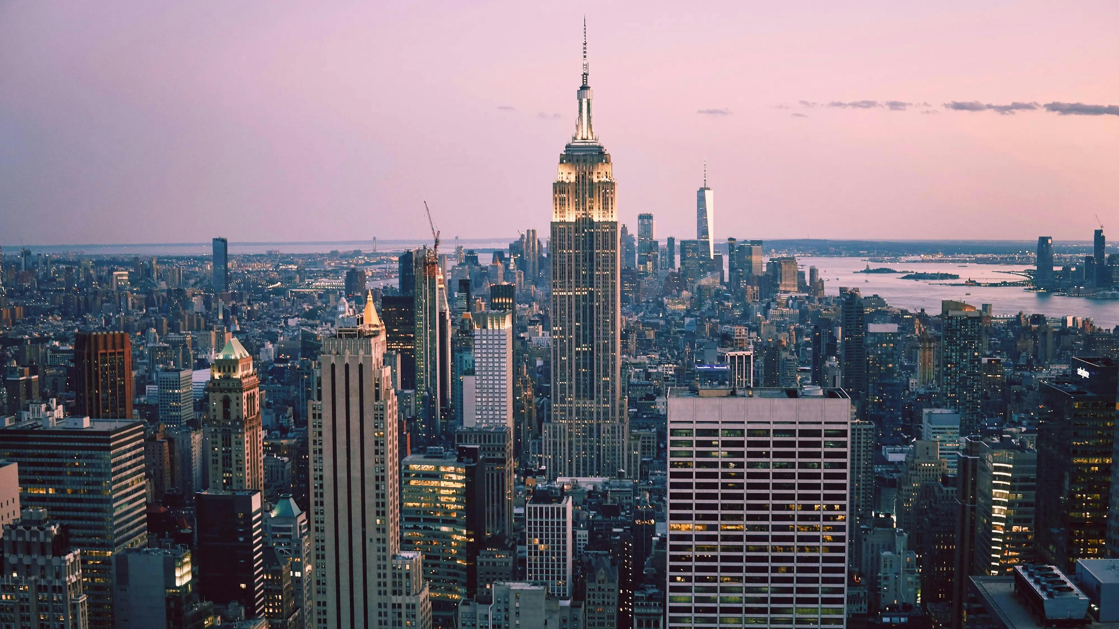 A captivating view of the New York City skyline at dusk, showcasing the iconic Empire State Building, sets the scene for the unparalleled dining experiences available through Booked, the leading restaurant reservation marketplace in New York.