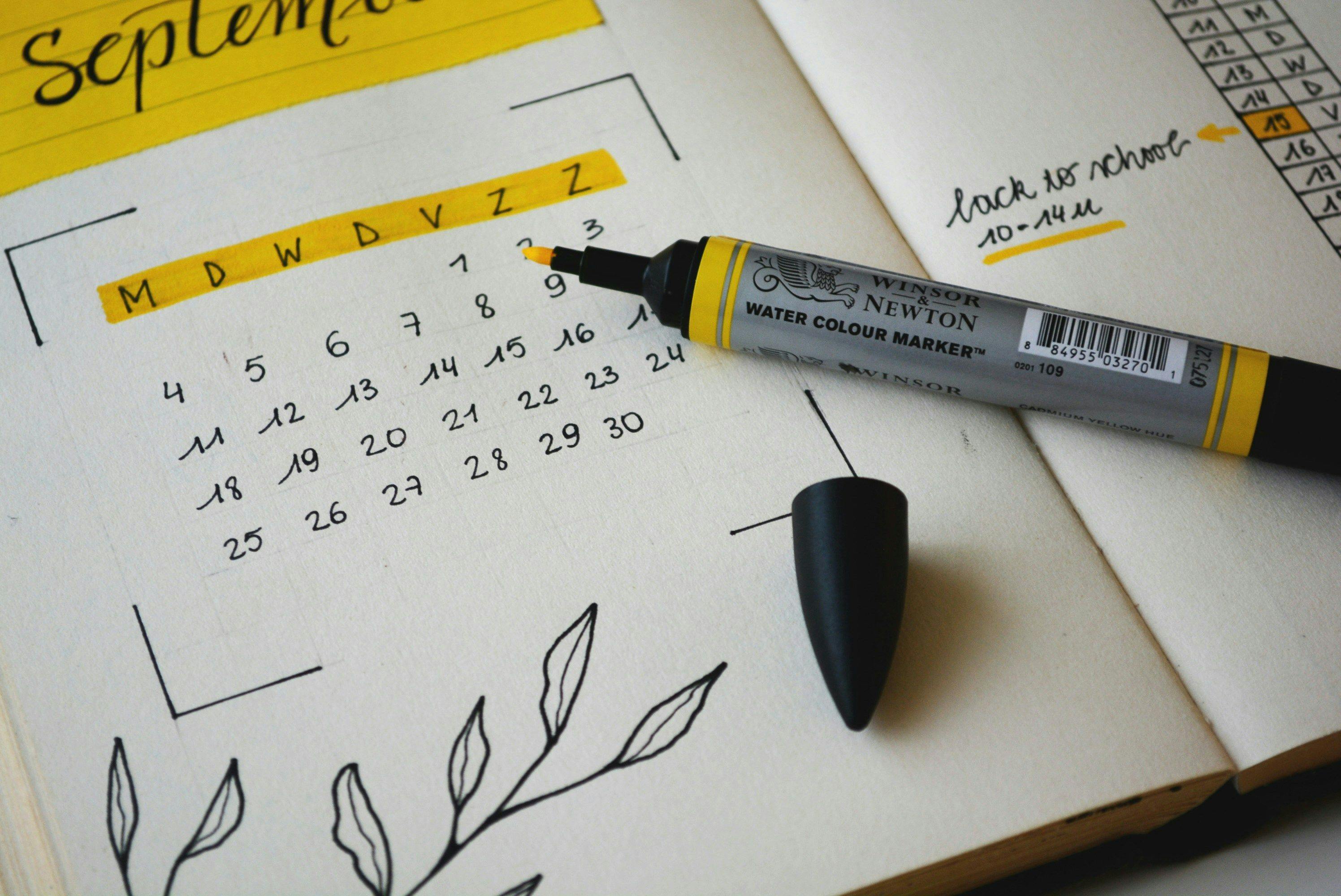A detailed bullet journal spread showing a hand-drawn September calendar with a yellow watercolor marker and a reminder for a restaurant reservation in New York, emphasizing personal organization and the anticipation of dining out.
